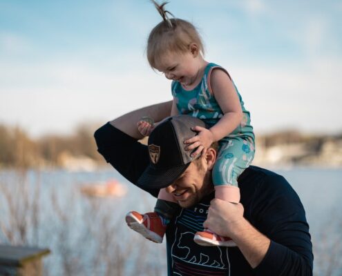 A father carrying his young daughter on his shoulders