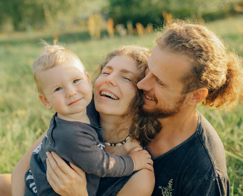 A picture of a smiling mother, father, and young child.